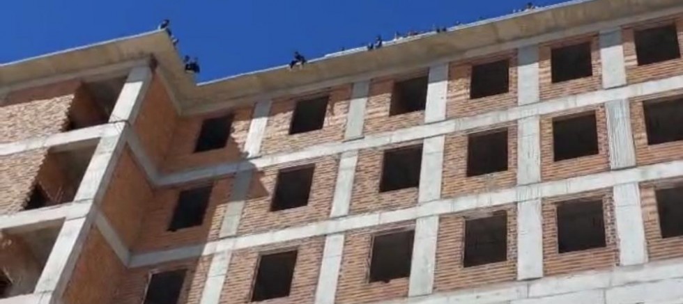 Maaşlarını alamayan işçiler binanın tepesine çıktı